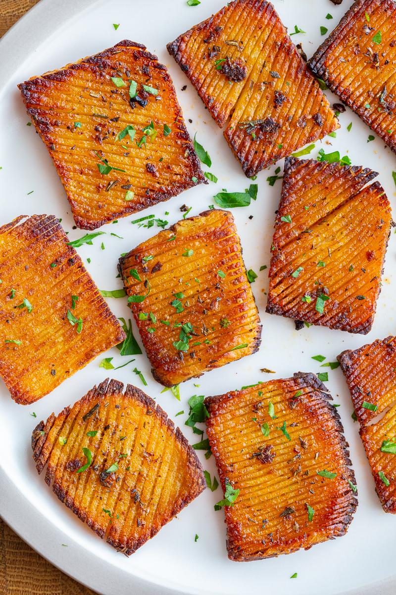 accordion potatoes on a plate sprinkled with parsley