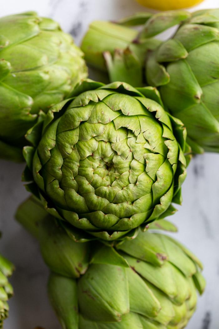 fresh artichokes stacked on top of each other