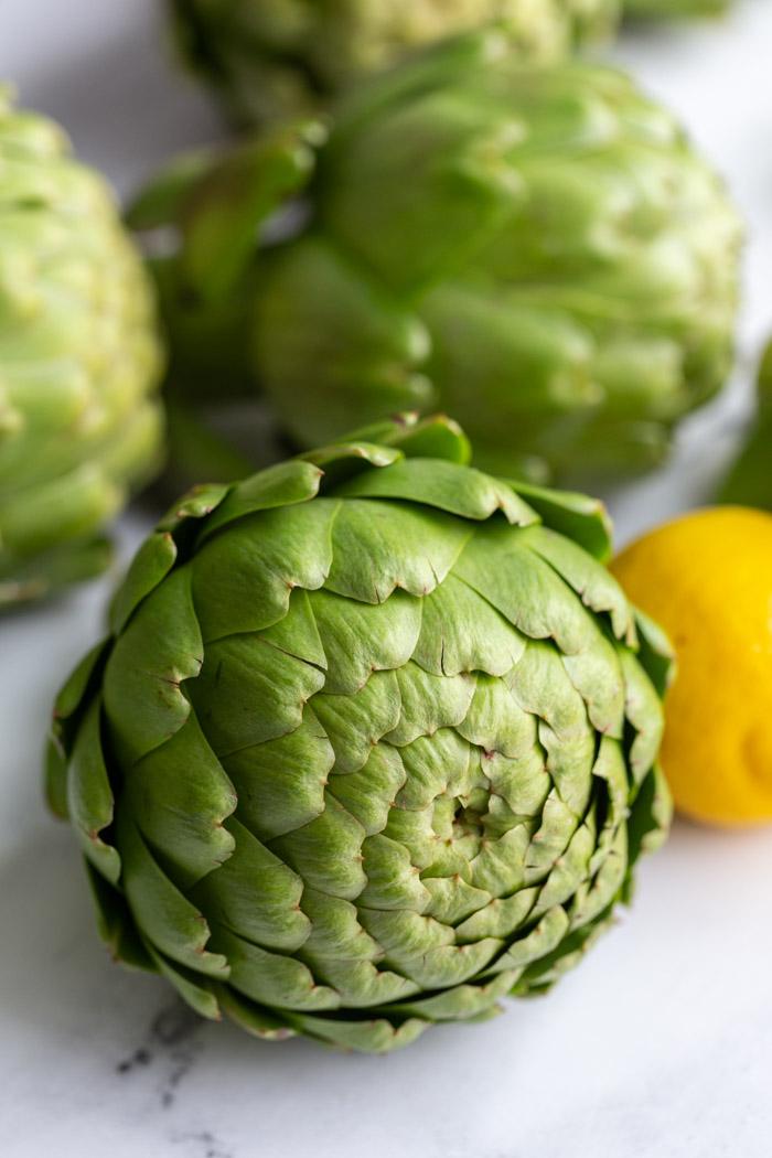 fresh artichokes stacked on top of each other
