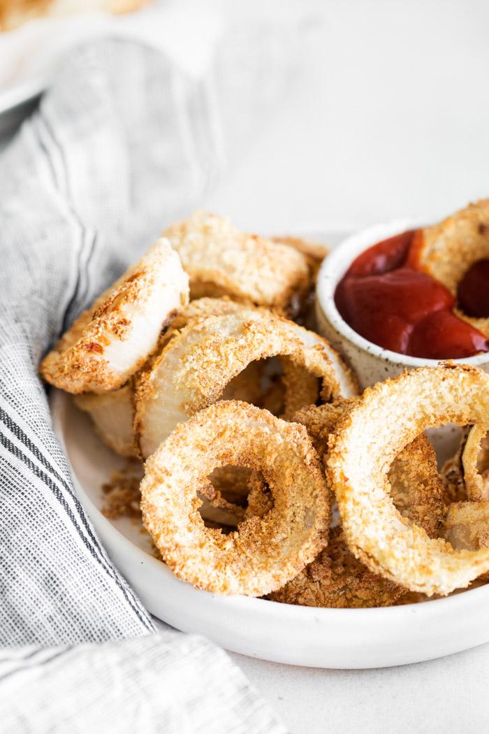air fryer onion rings in a basket served with ketchup