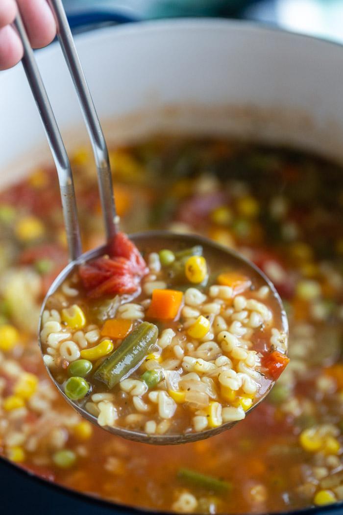 up close shot of a laddle full of alphabet soup