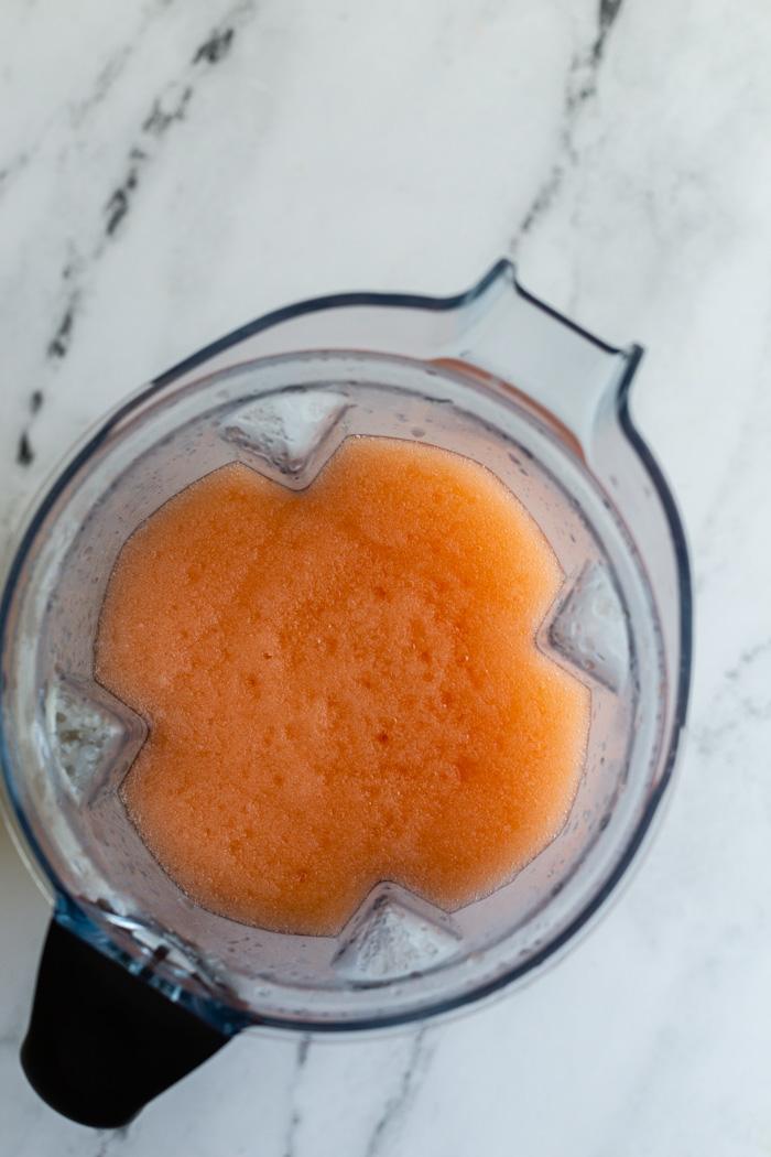 top down shot of a vitamix blender filled with an aperol spritz slushie