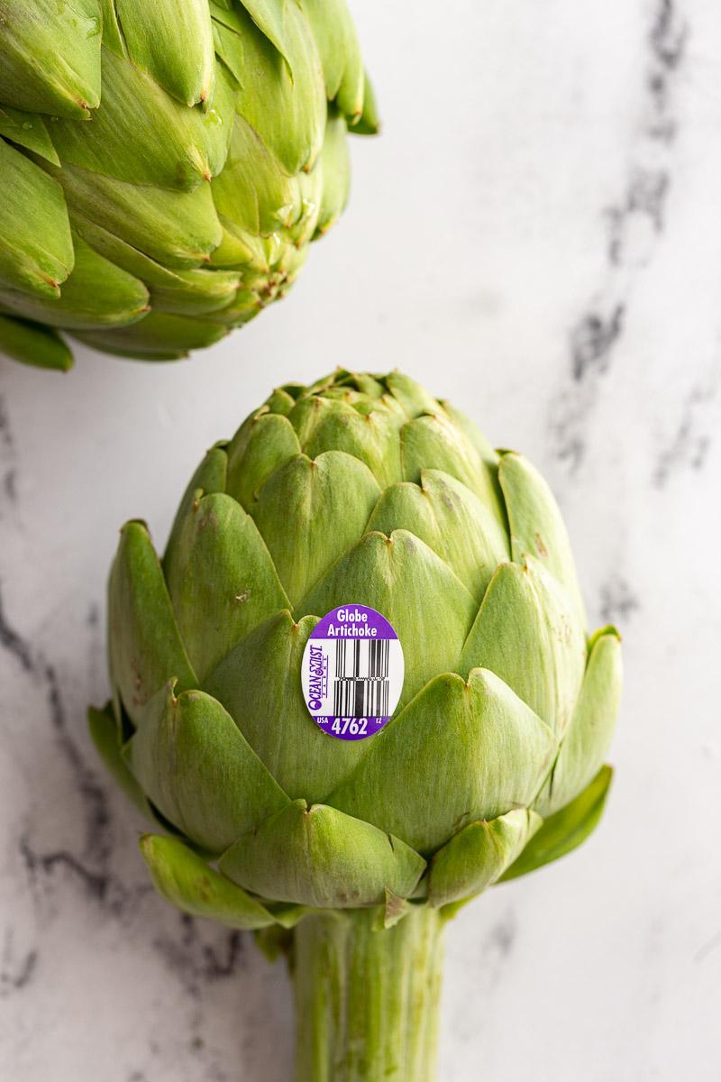 aw artichokes with a produce sticker on them