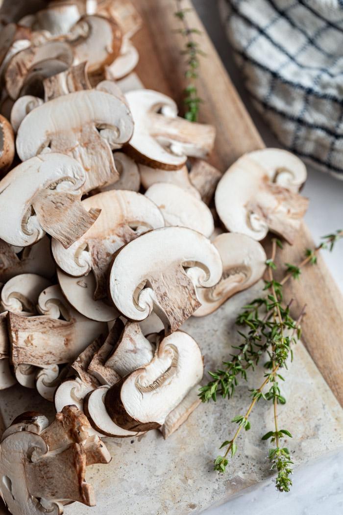 sliced mushrooms on a wooden cutting board