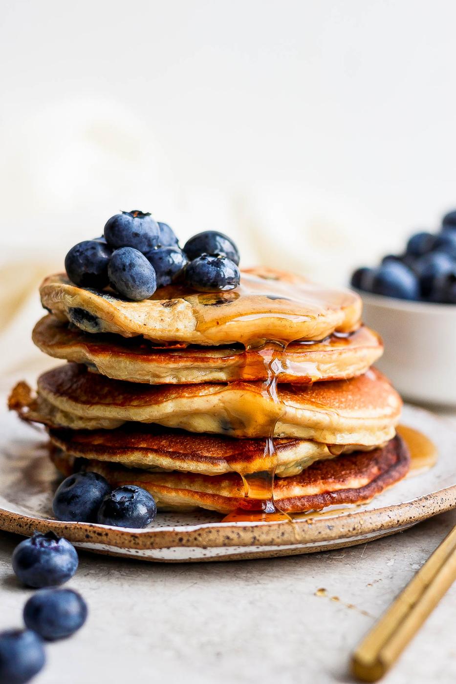 Pancakes staked and drizzled with maple syrup.
