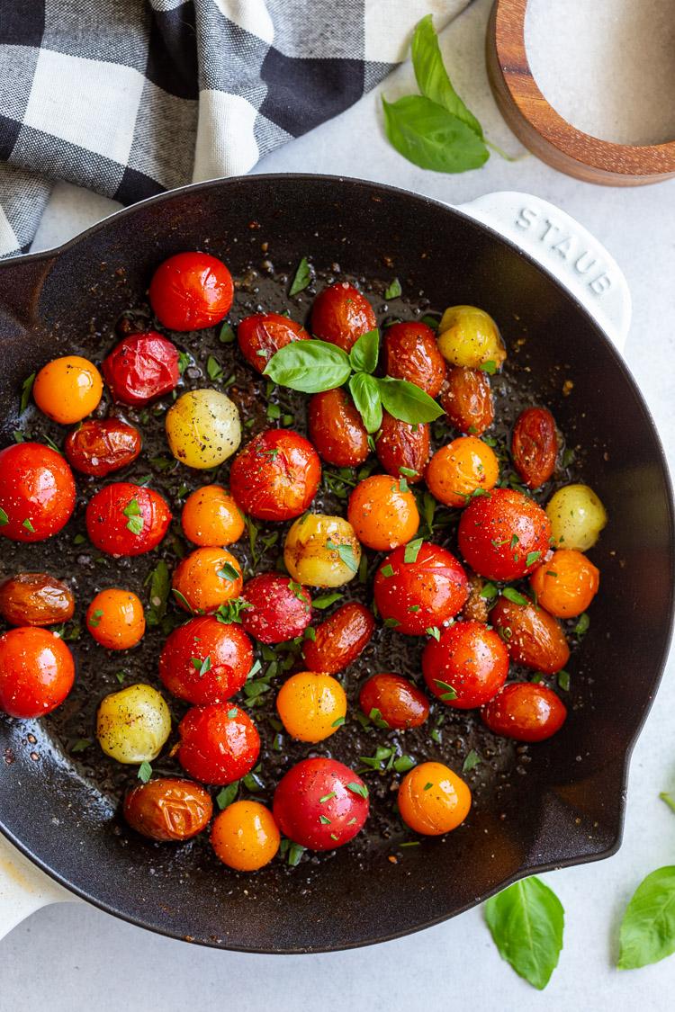 cast iron skillet filled with blistered tomatoes