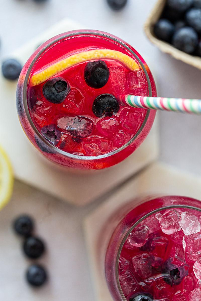 Overhead view of blueberry lemonade garnished with blueberries and lemon slices.