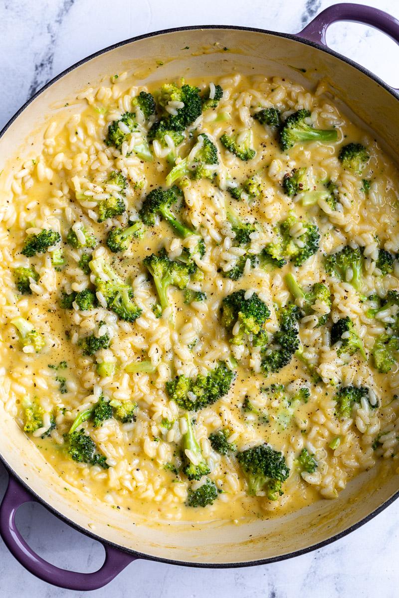 Making a cheesy broccoli rice in a large pot.