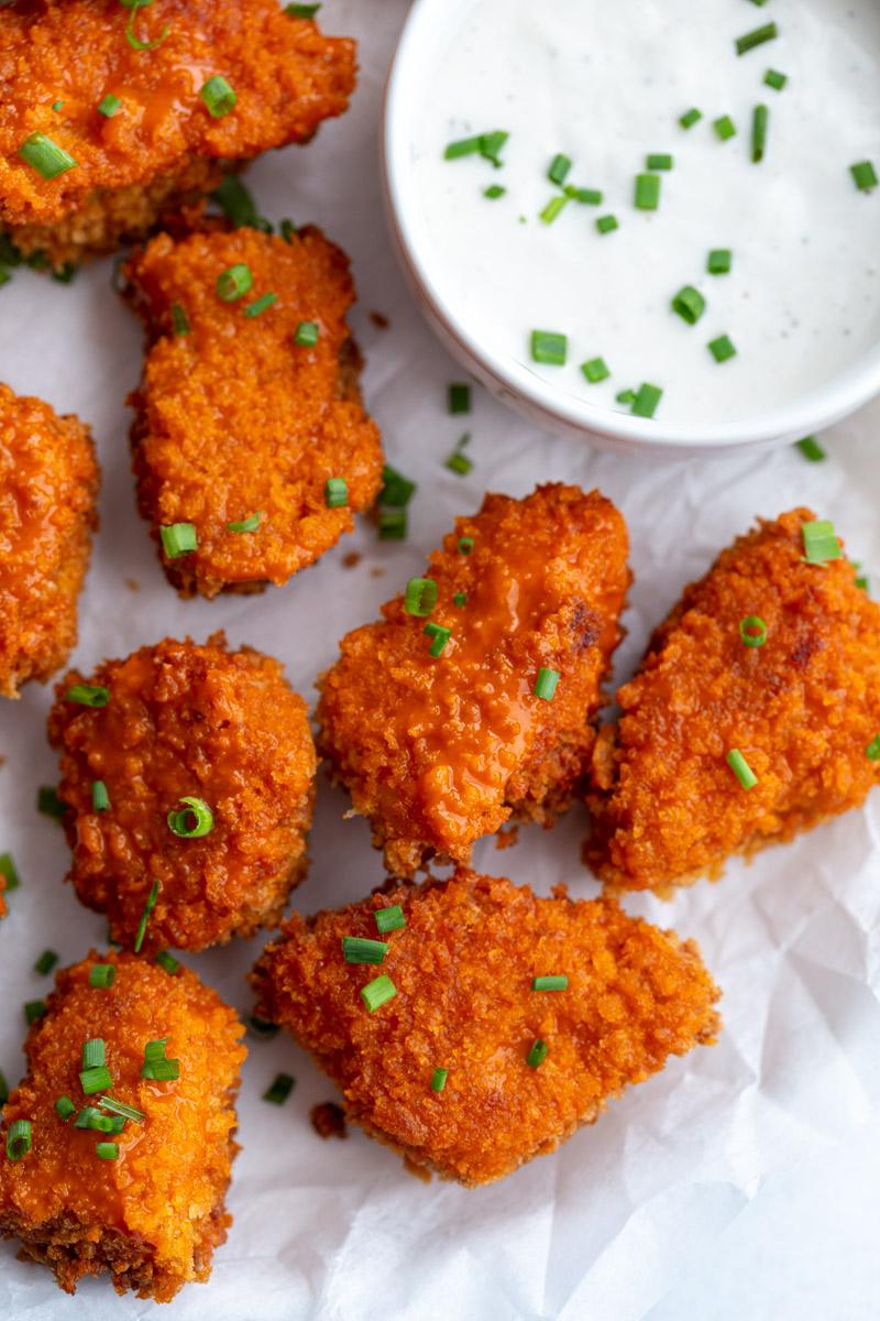 buffalo tempeh garnished with chives and served with a ranch dressing