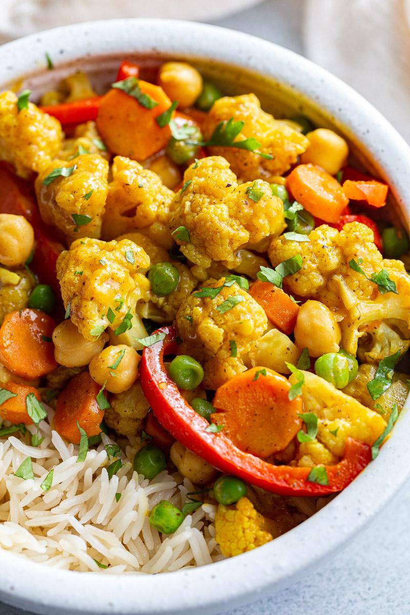 Cauliflower curry in a white bowl with rice.