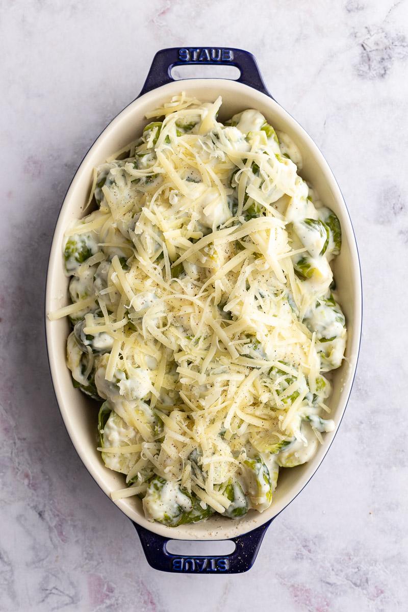 brussels sprouts au gratin topped with fresh cheese
