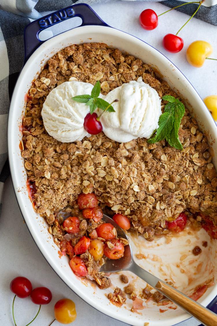 spoon dishing into cherry crisp
