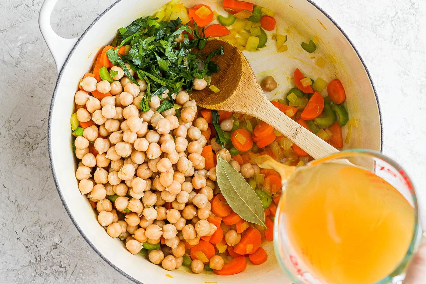 Stirring broth into other ingredients for soup.