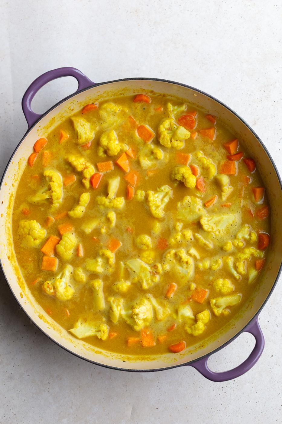 cauliflower and carrot curry being cooked in a skillet