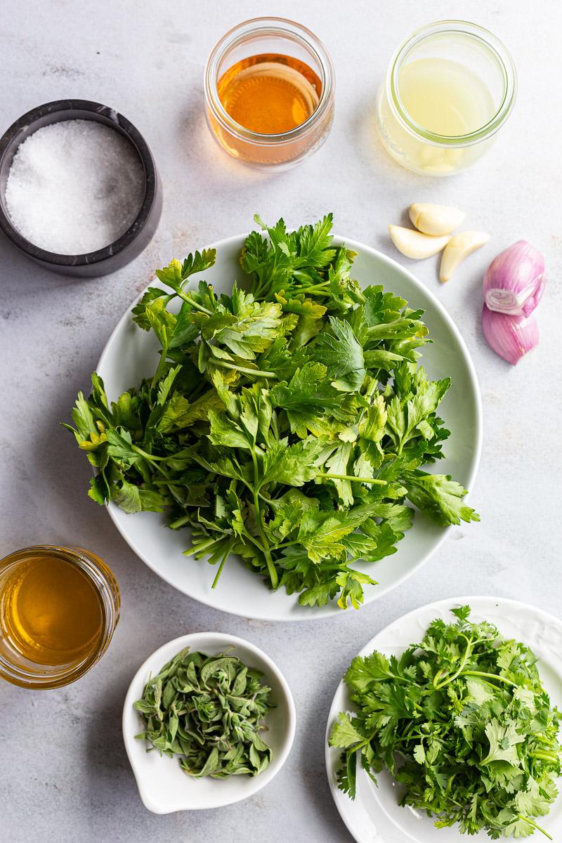Fresh herbs and other ingredients needed to make chimichurri sauce.
