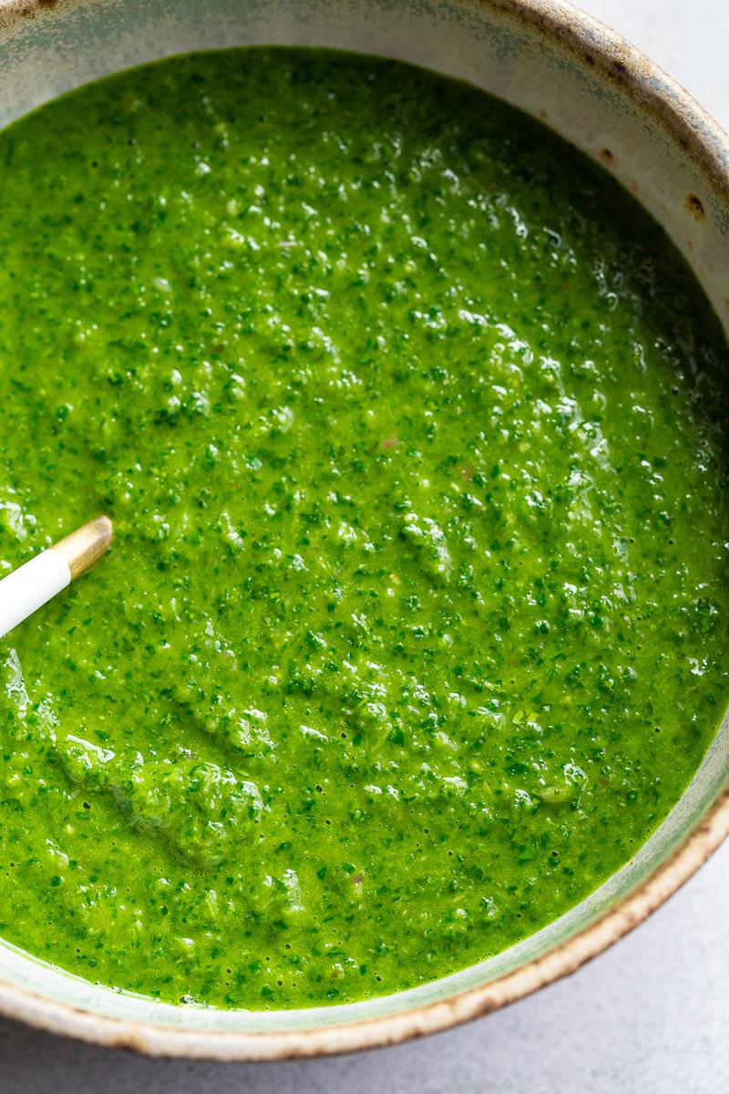 Green herby sauce served in a bowl.