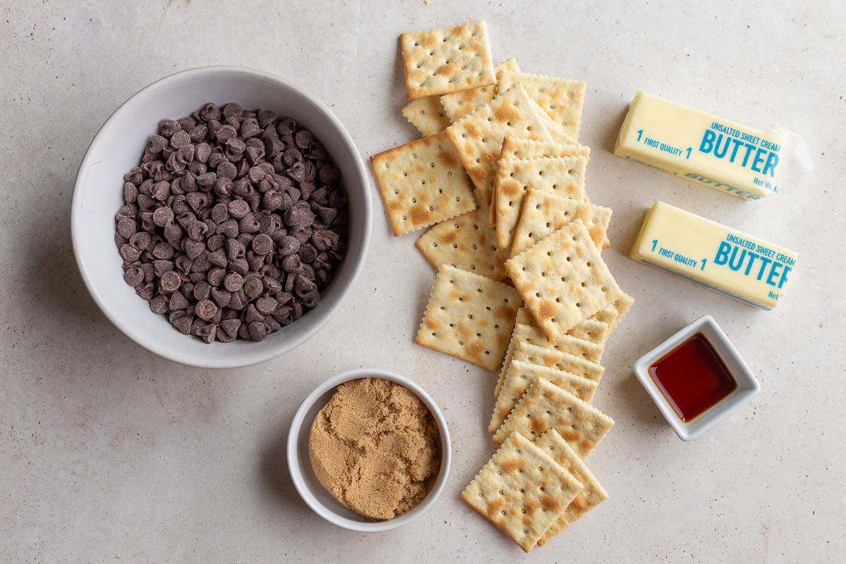 ingredients needed to make christmas crack including saltine crackers, chocolate chips, brown sugar, and butter