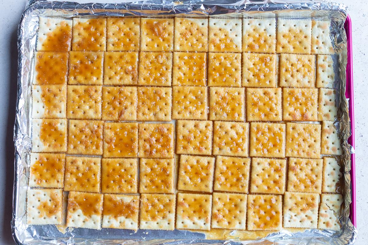how to make christmas crack: picture of saltine toffee after being baked in the over