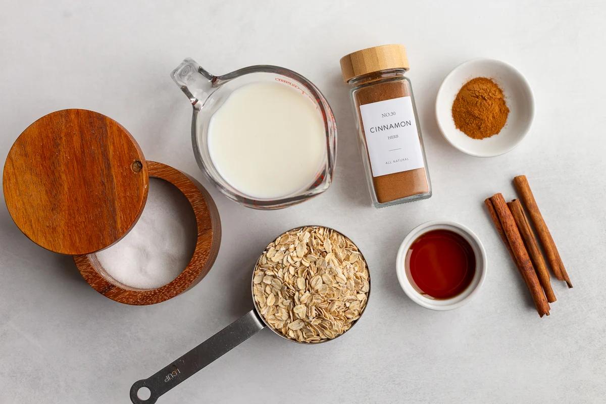 ingredients needed to make cinnamon oatmeal on the stovetop including oats, milk, salt, cinnamon, and vanilla