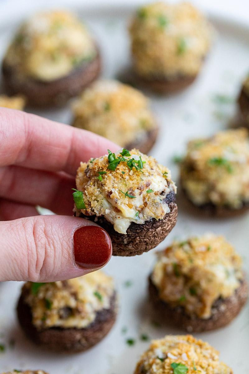 Woman's hand holding a stuffed mushroom.
