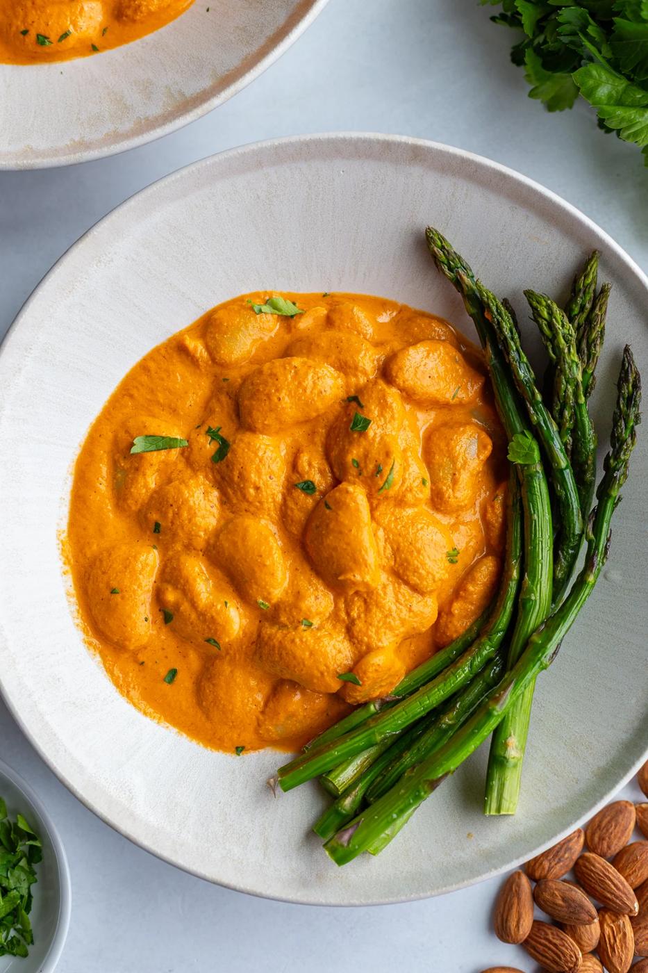romesco butterbeans in a bowl with asparagus