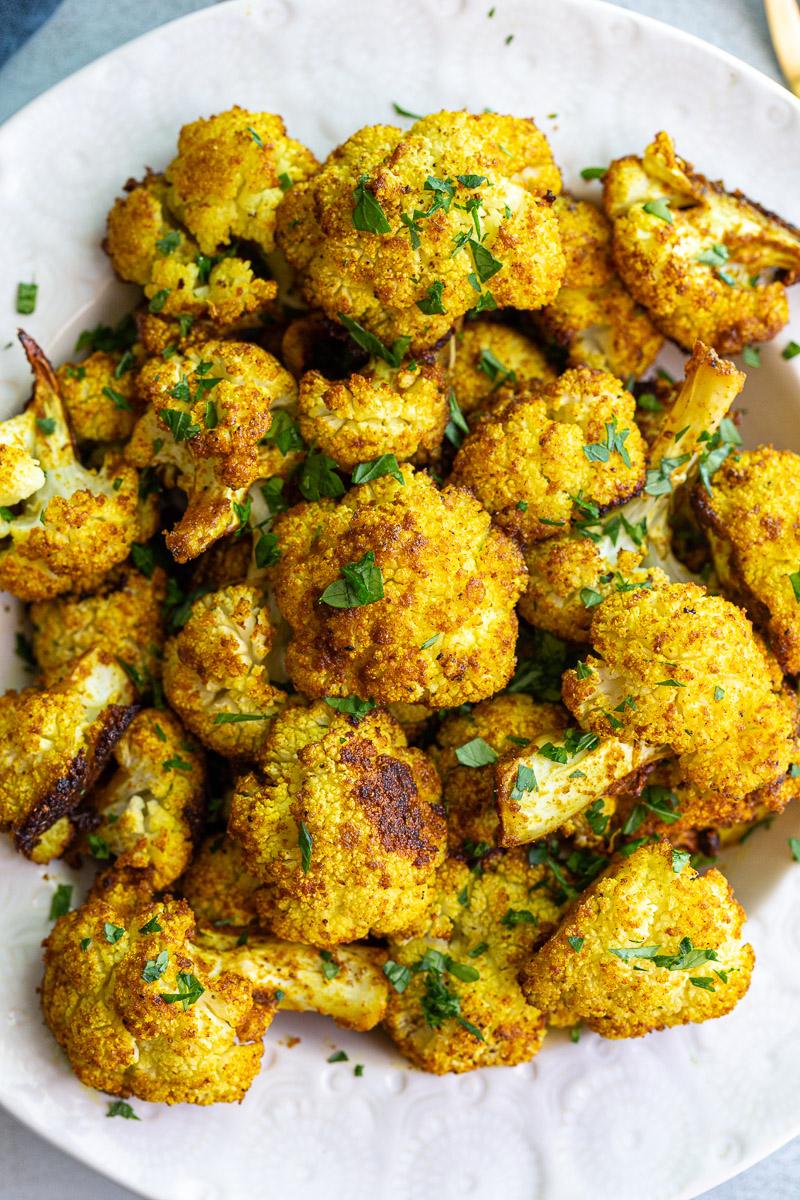 Cauliflower roasted with curry and garnished with fresh cilantro.