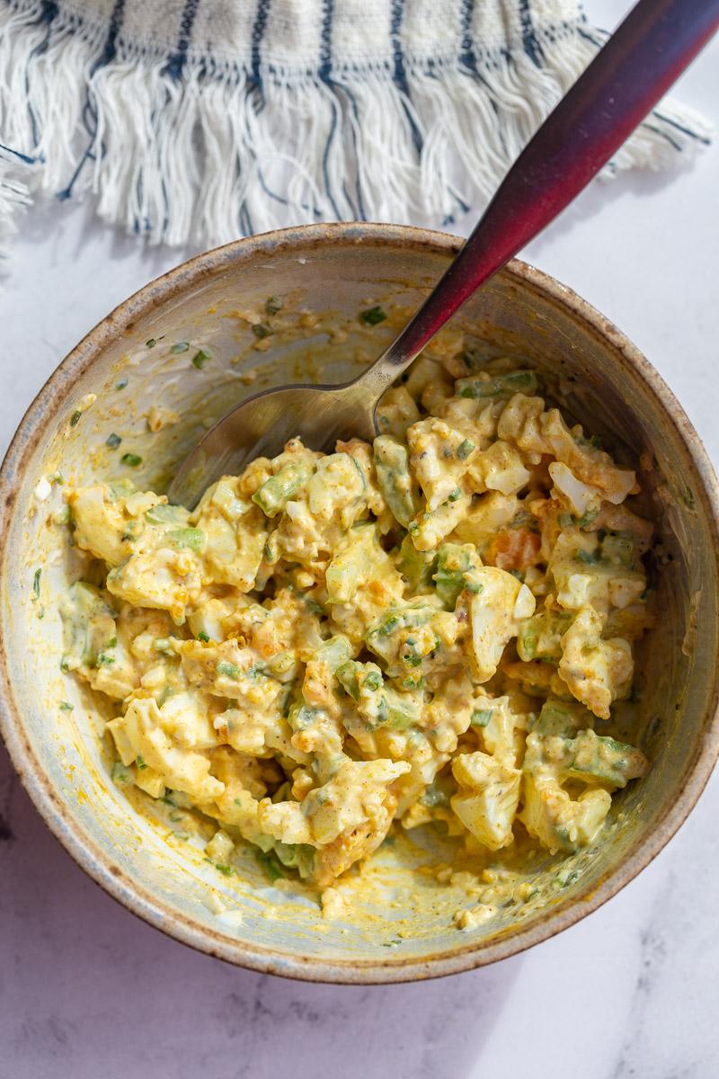 curried egg salad in a small bowl with a spoon