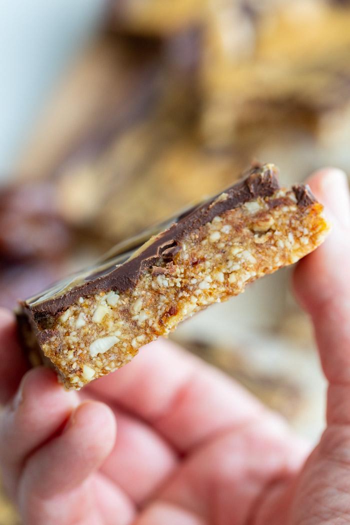 side shot of a date nut bar that has chocolate on the top