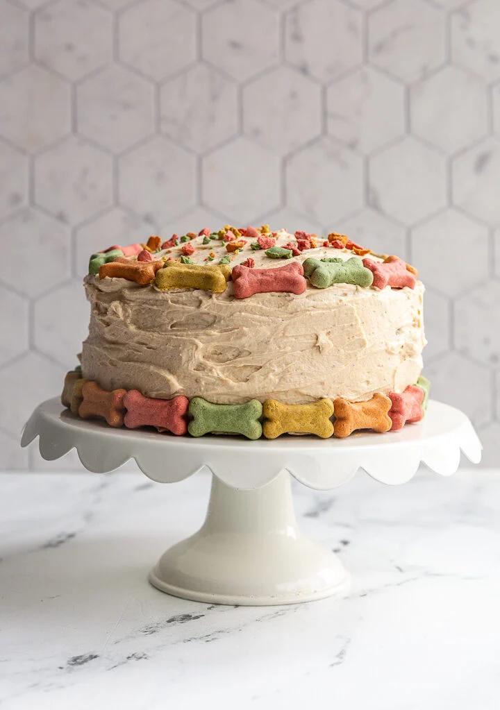 dog birthday cake covered in mini milkbones on a small cake stand