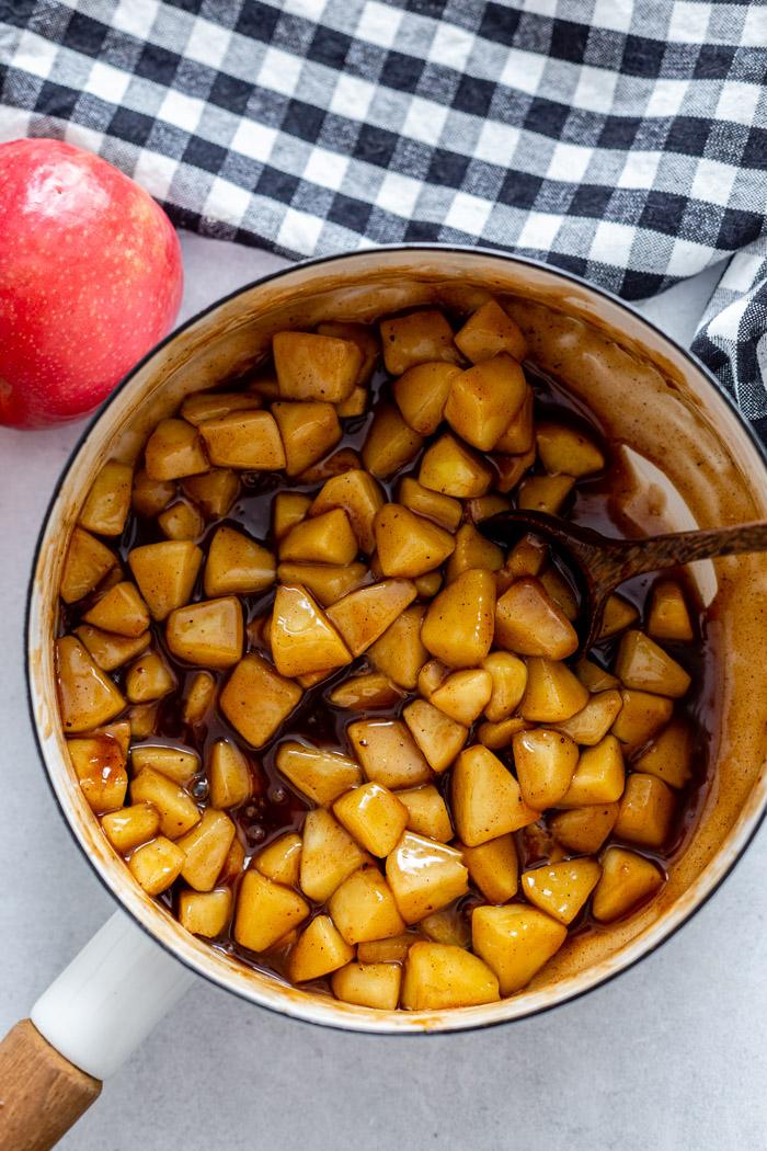 white pot filled with juicy sauted apples