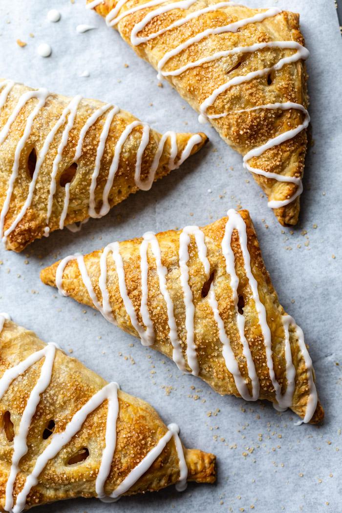 iced apple turnovers on parchment paper