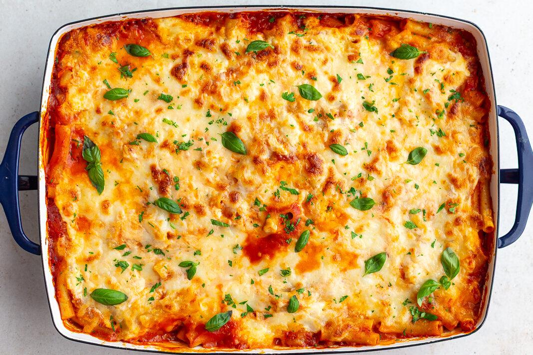 old-school baked ziti without meat in a large casserole dish and topped with fresh basil
