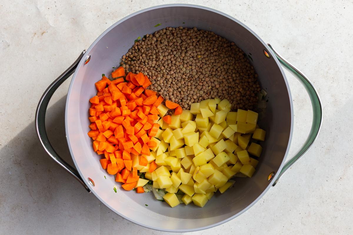 carrots, potato, and dried lentils in a pot