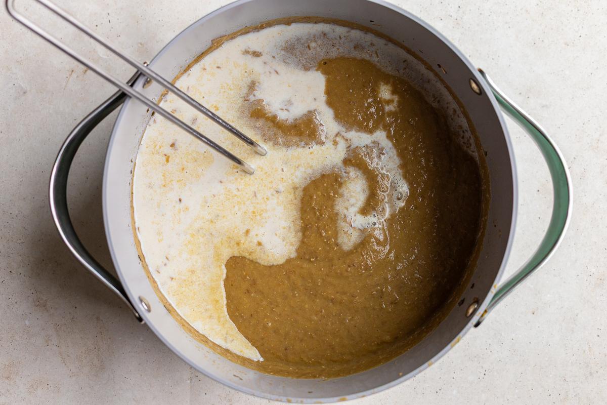 creamy lentil soup in a large pot with milk simply poured in before being stirred