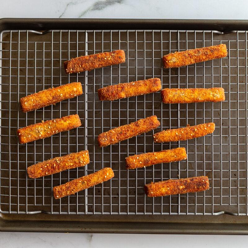 halloumi fries on a wire rack cooling after being fried