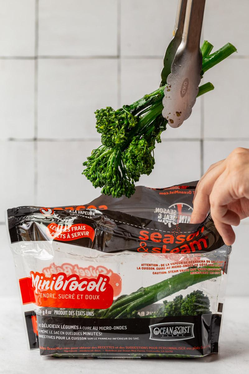 baby broccoli being pulled out of an ocean mist steam bag