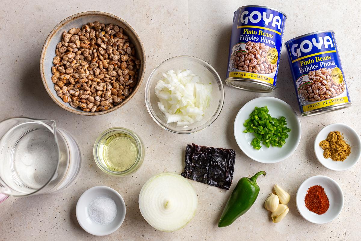 ingredients need to cook this refried beans recipe including dried pinto beans, onion, jalapeno, water, and spices