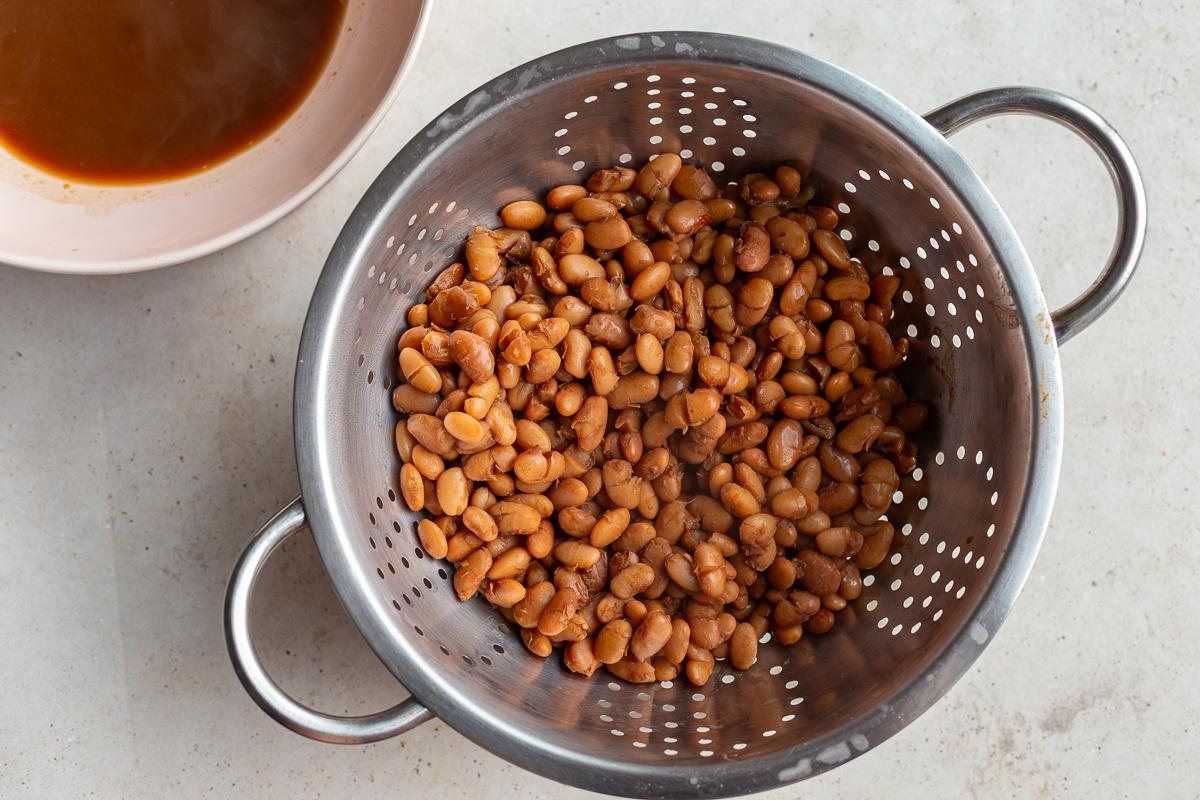 cooked pinto beans in a colander