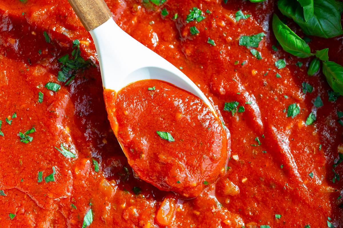marinara sauce with a white spoon in it