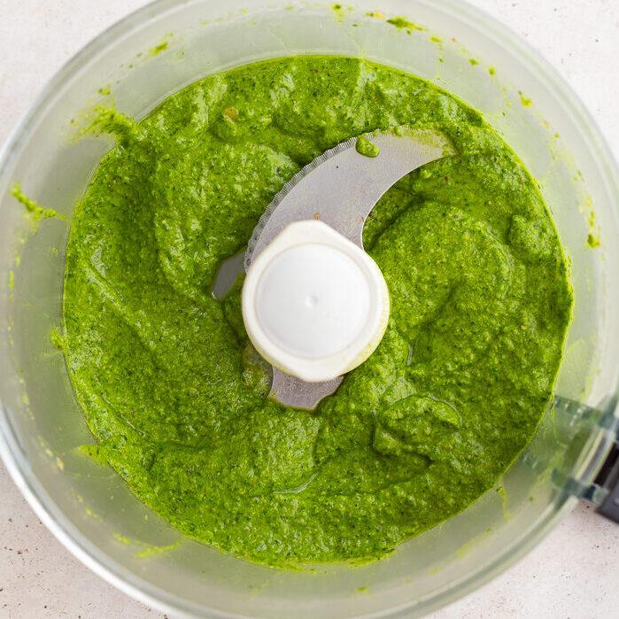 fresh kitchen-made pesto blended up in a food processor base.