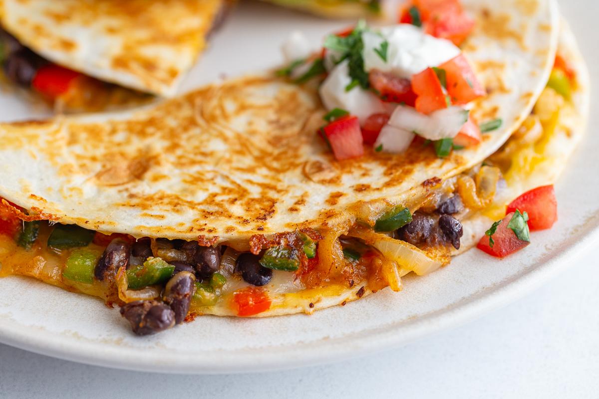 stack of vegetarian quesadillas with bell pepper, onion, cheese, and black beans