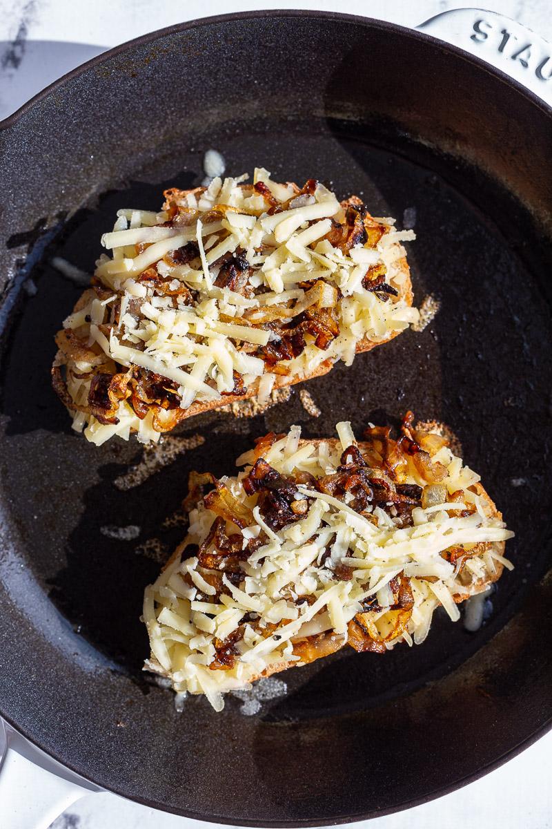 caramelized onion grilled cheese being cooked in a cast iron skillet