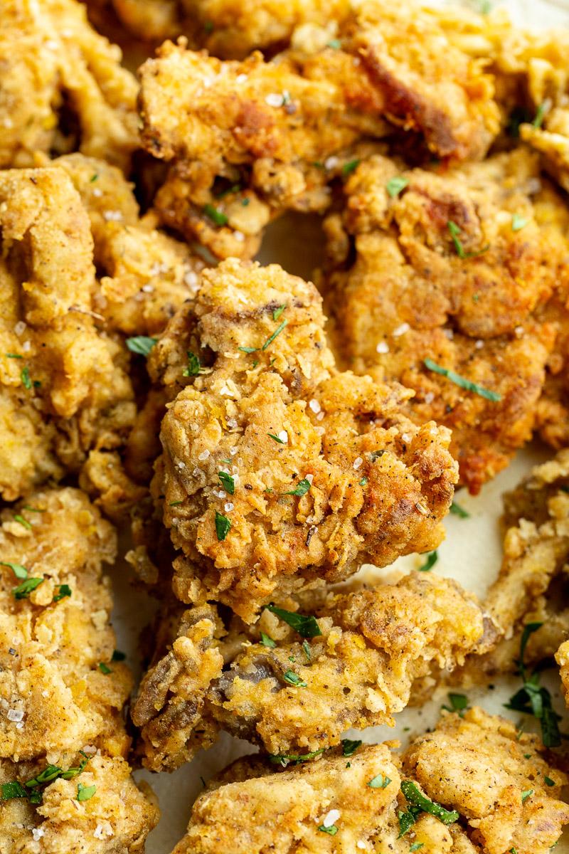 Fried mushrooms garnished with a sprinkle of fresh parsley.