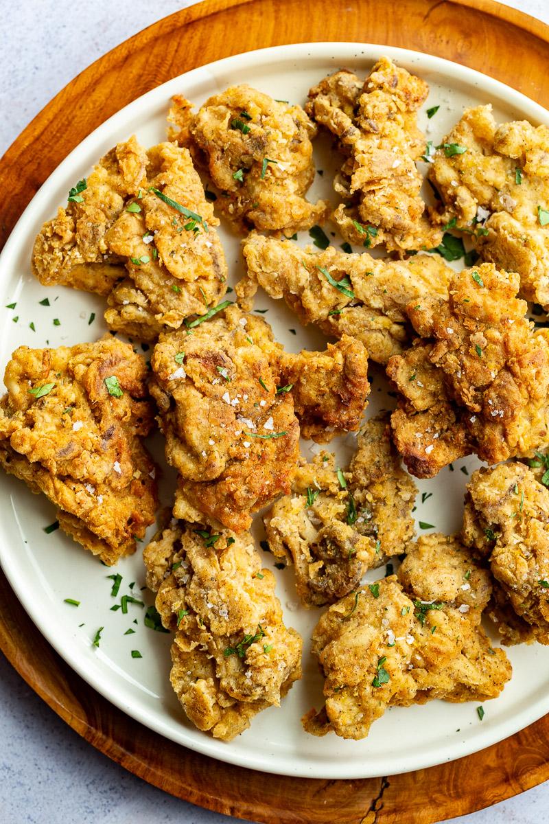 Oyster mushrooms that have been fried and served on a white plate.