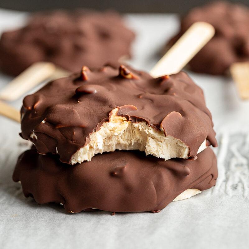 frozen yogurt chocolate bars on a stick with a bite taken out