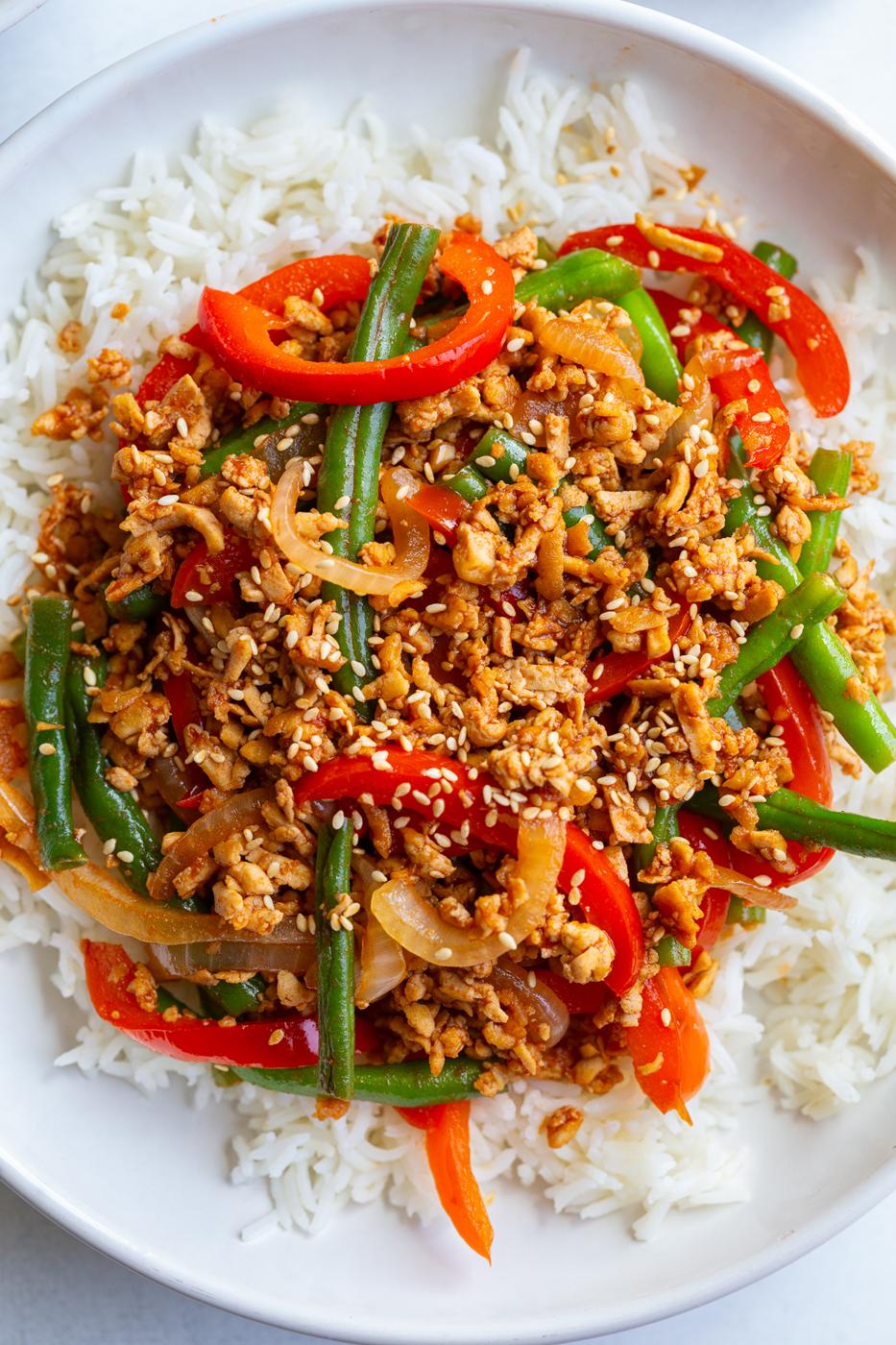 ground tofu stir fry with red bell pepper and green beans on a bed of white rice