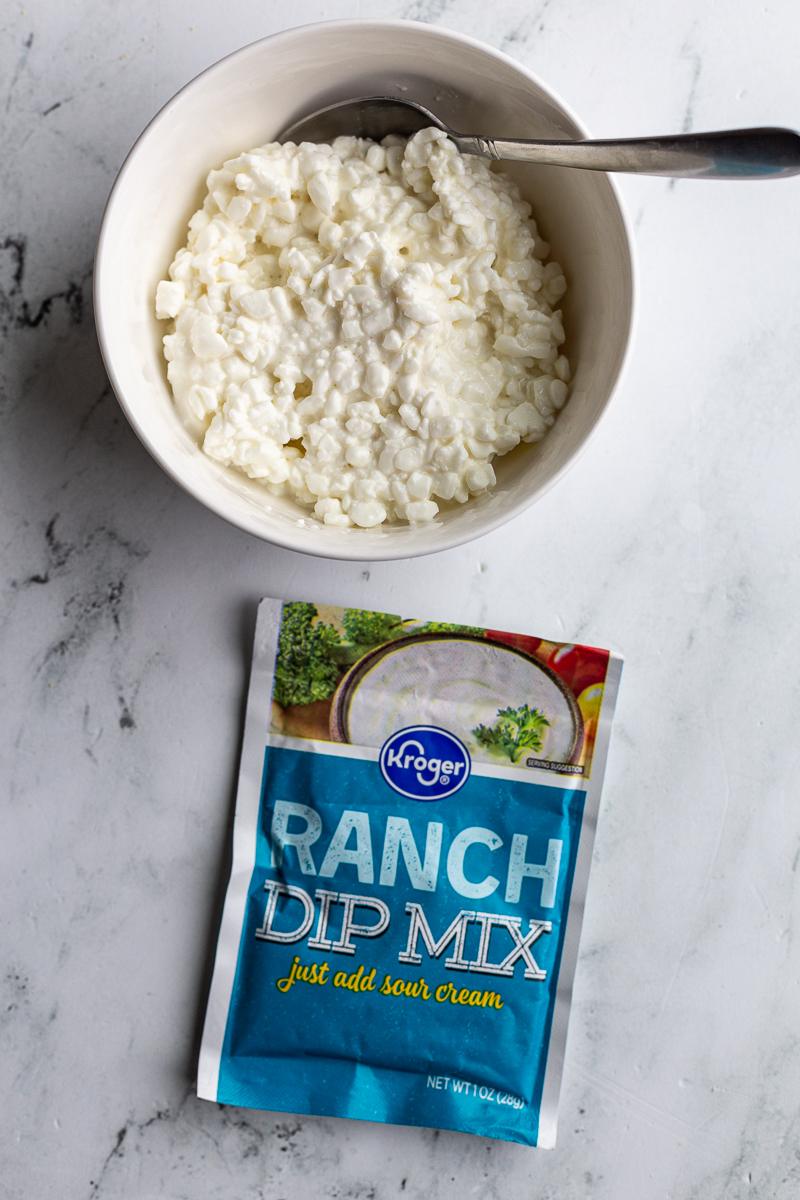 cottage cheese ranch ingredients: cottage cheese in a bowl with a packet of ranch seasoning next to it