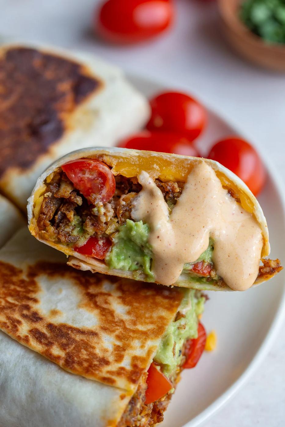 high protein tofu burrito drizzled with cheese sauce