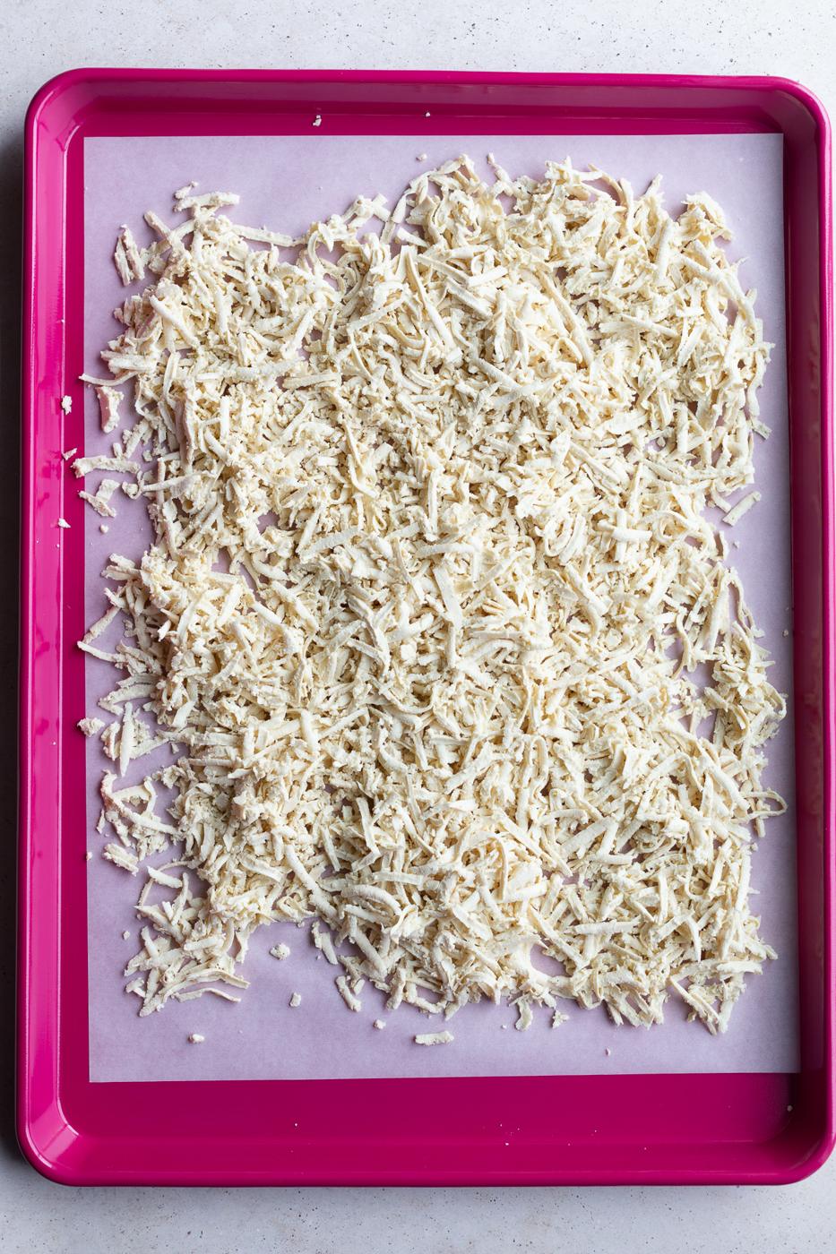 shredded tofu on a large red baking sheet