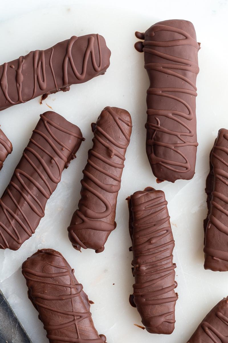 top down shot of from-scratch twix chocolate bars. There's extra chocolate drizzled on top of them in a swirled pattern